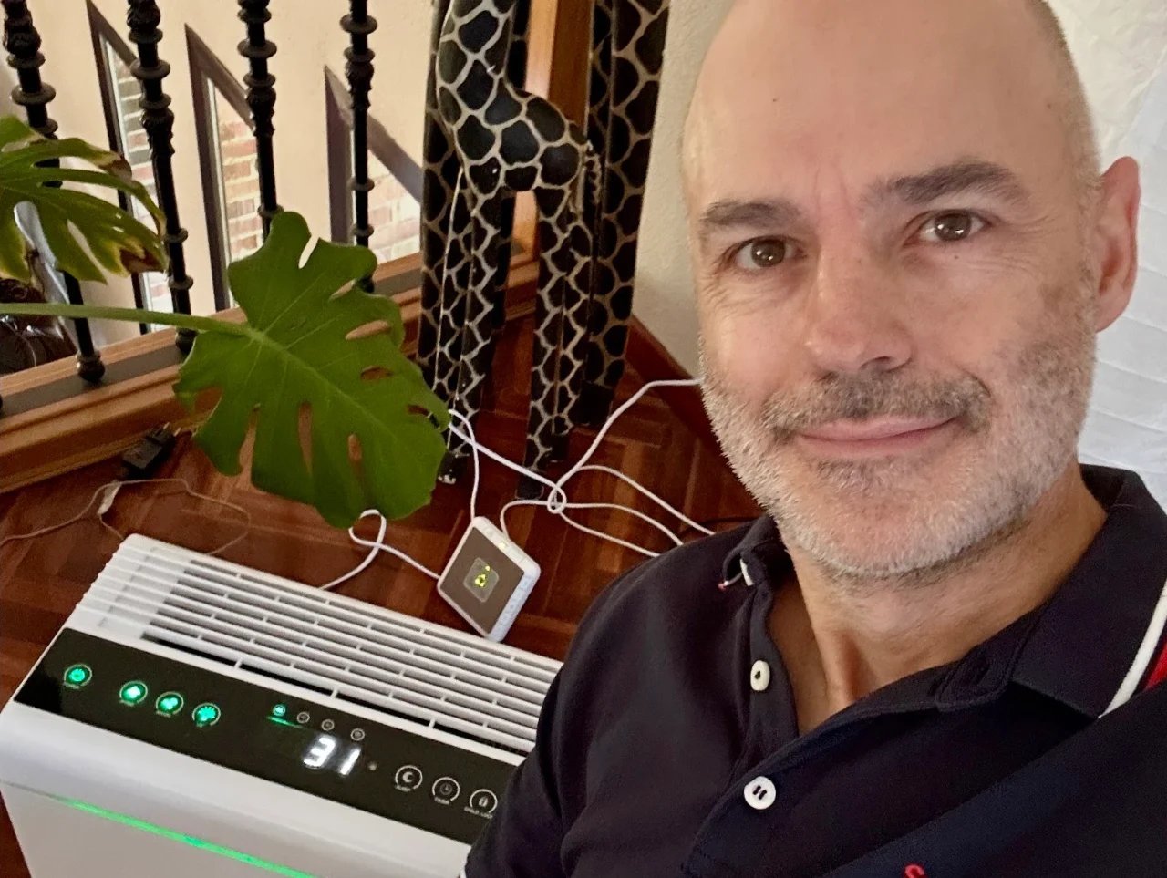 Pedro Nó junto al purificador de aire Brisa 7 con el medidor de partículas dentro de casa