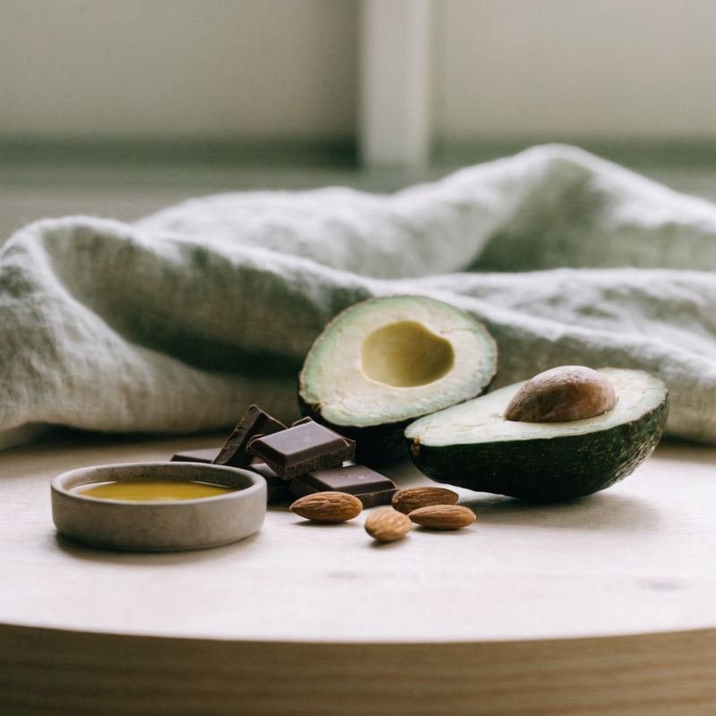 Aguacate, almendras, chocolate negro y aceite de oliva sobre madera